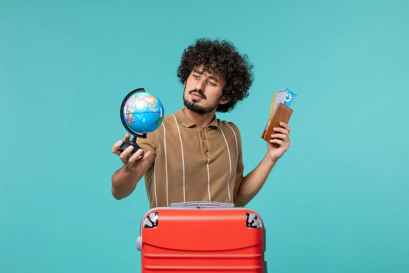 Фронтальный вид мужчины в отпуске, держащего глобус и билет, на синем фоне.