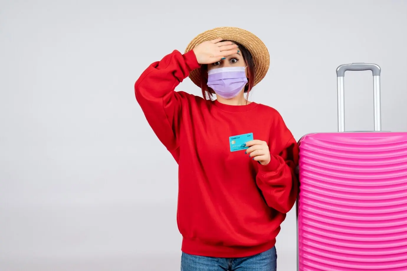 Вид спереди: молодая женщина в маске готовится к поездке на фоне белой стены.